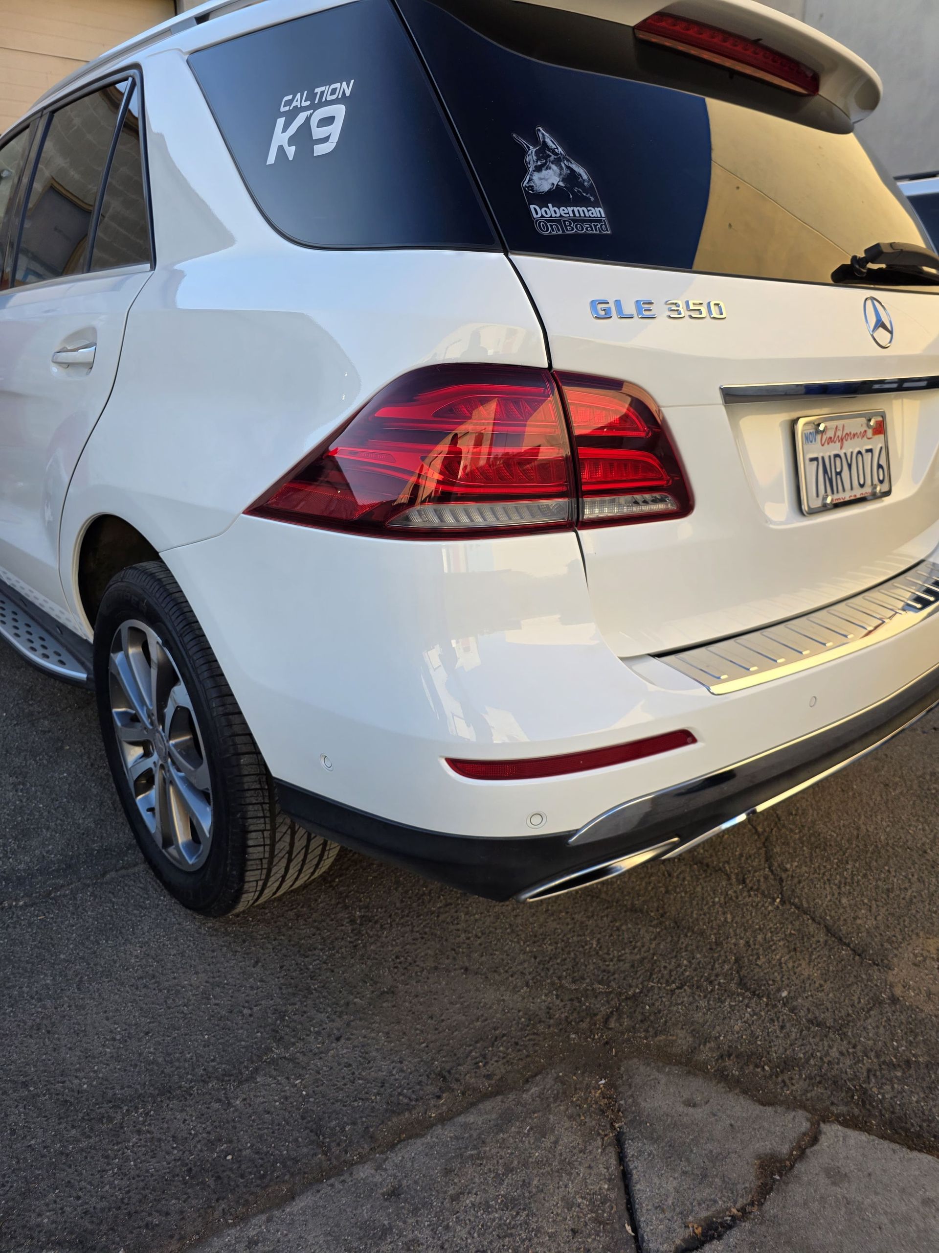 Rear view of a white Mercedes-Benz SUV parked on pavement, with tinted windows and a visible license plate.