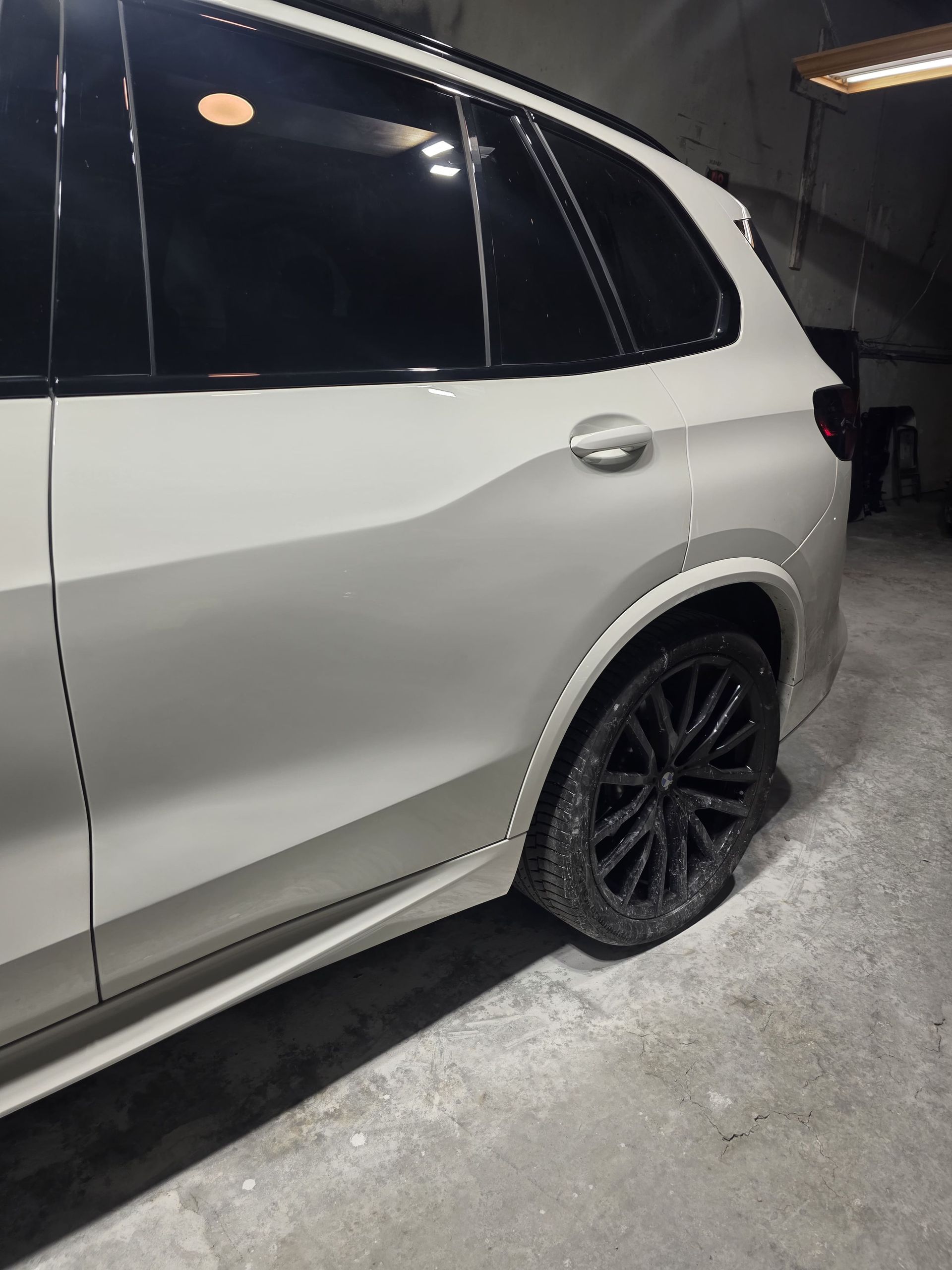 Silver SUV with tinted windows and black wheels parked in a garage
