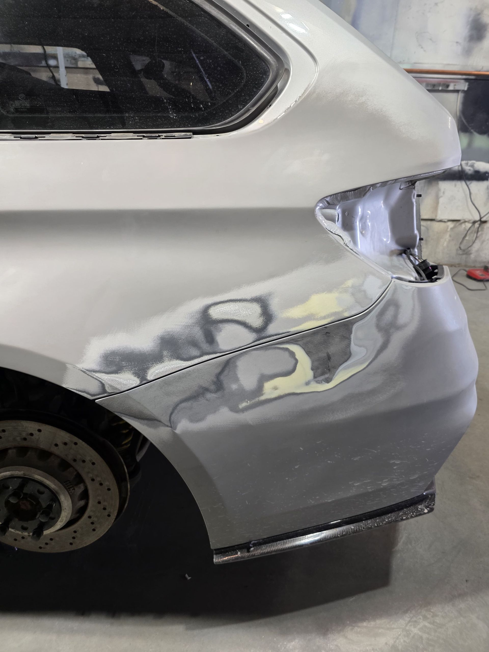 Silver SUV with rear quarter panel and bumper severely dented and scraped after collision