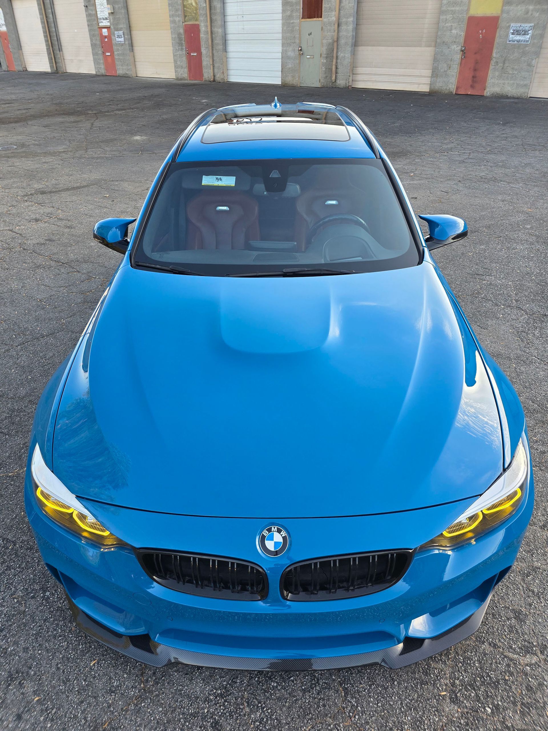 Blue BMW coupe viewed from the front in a parking area