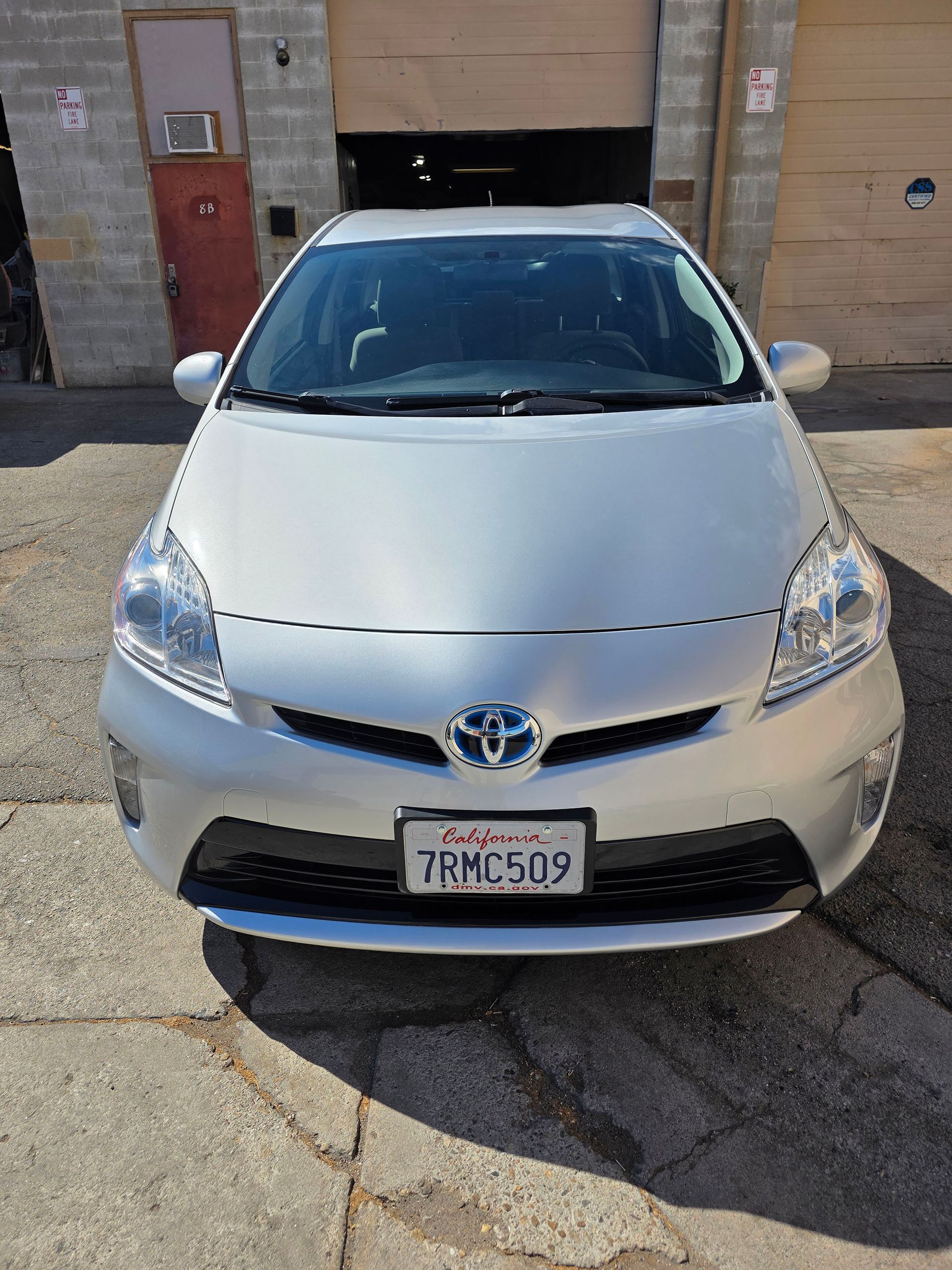 Silver Toyota sedan parked in front of a building, viewed from the front