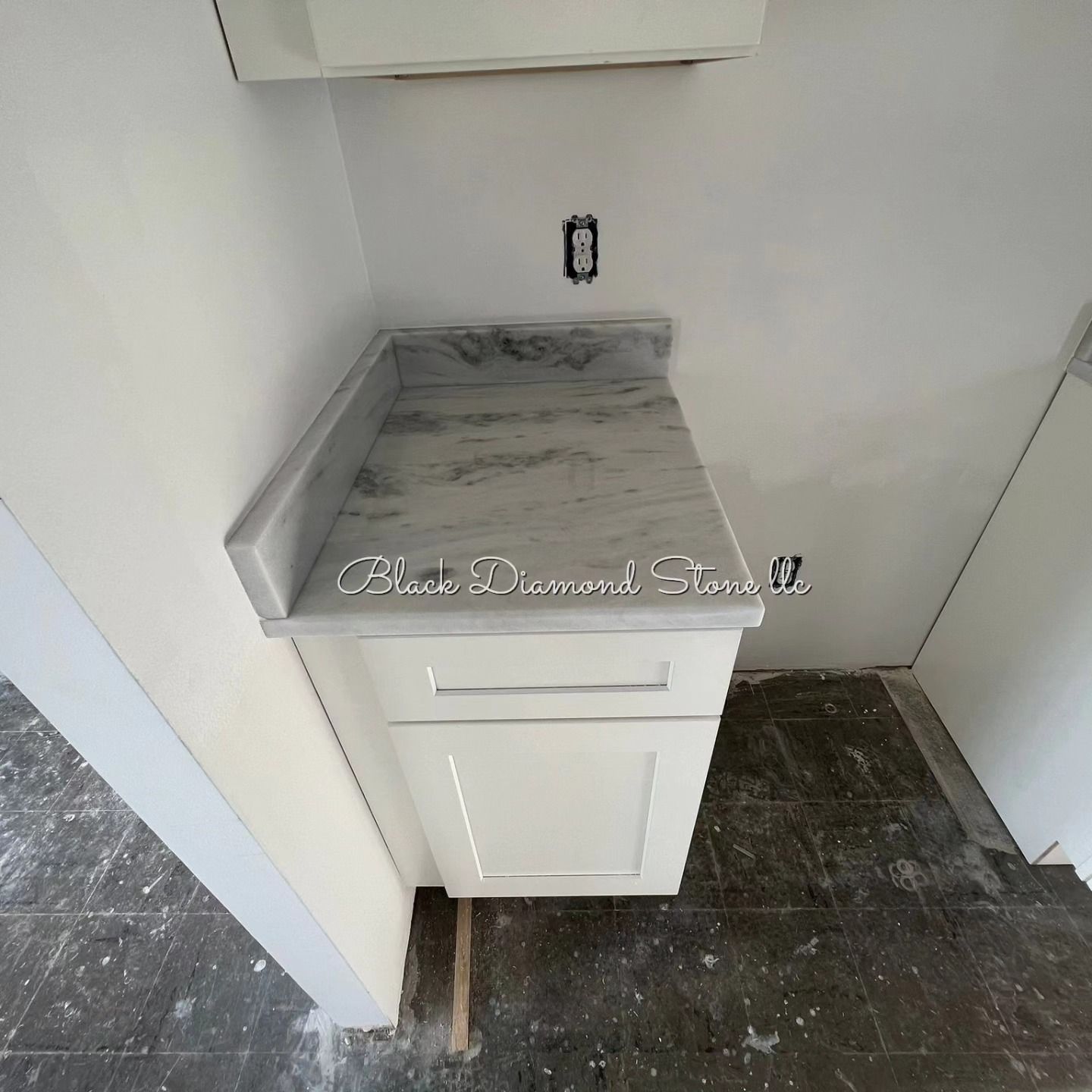 a white cabinet with a marble countertop in a kitchen