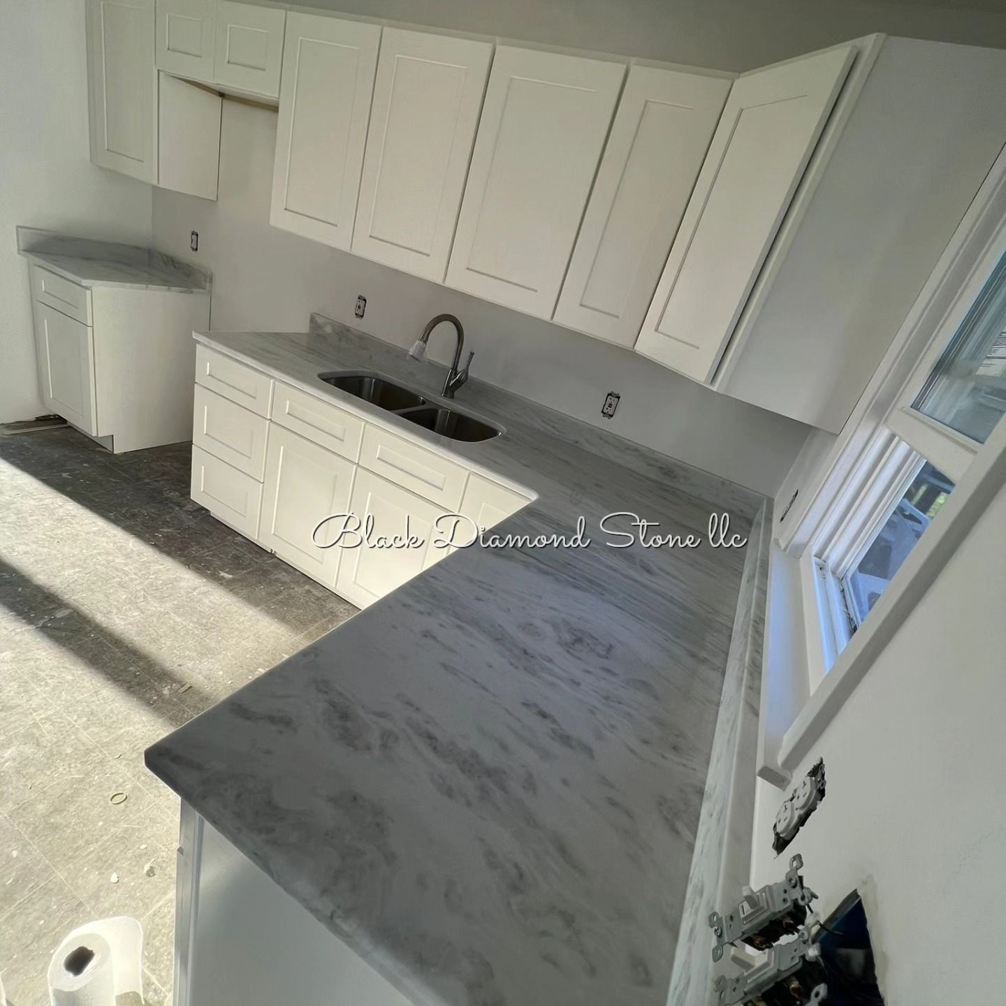 a kitchen with white cabinets and a granite countertop