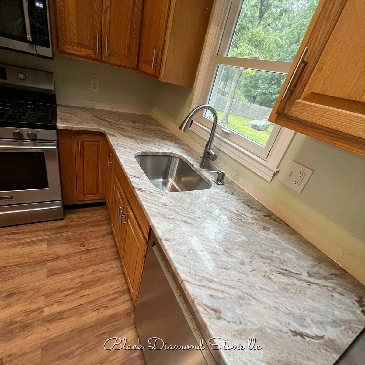 a kitchen with granite countertops, stainless steel appliance , and wooden cabinets