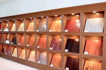 Display of wood flooring samples in a showroom, various colors and finishes on display.