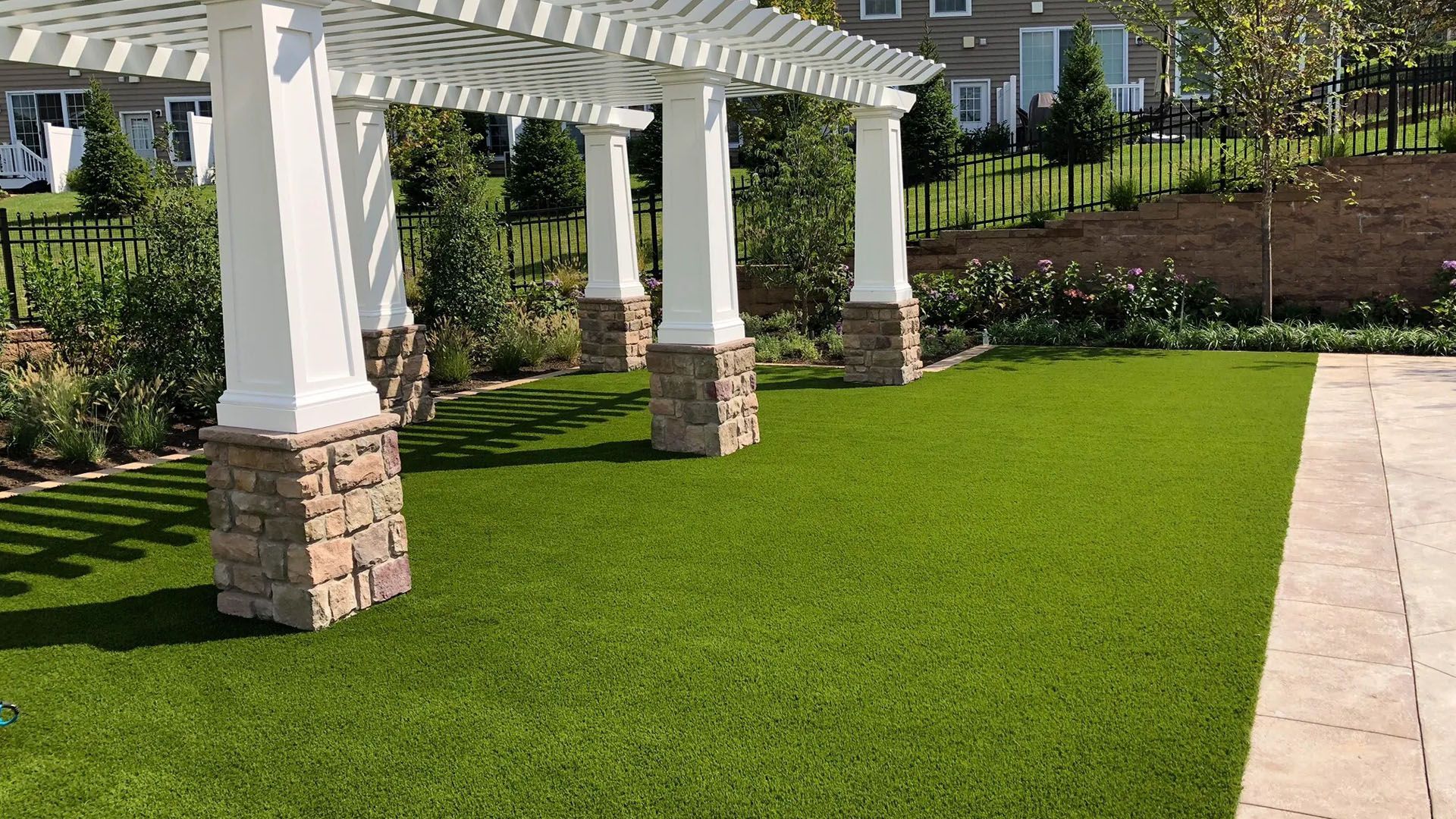 A pergola is sitting on top of a lush green lawn.
