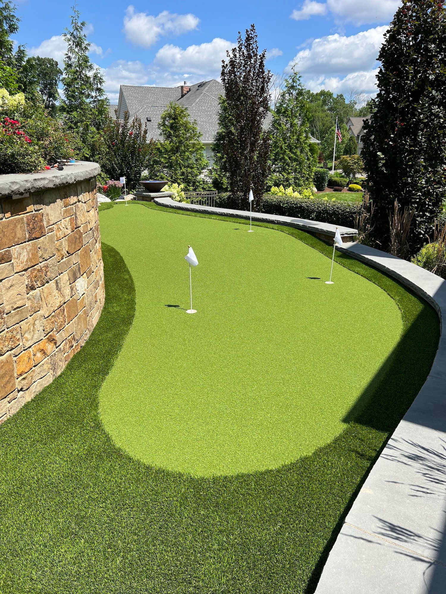 There is a putting green in the middle of the yard.