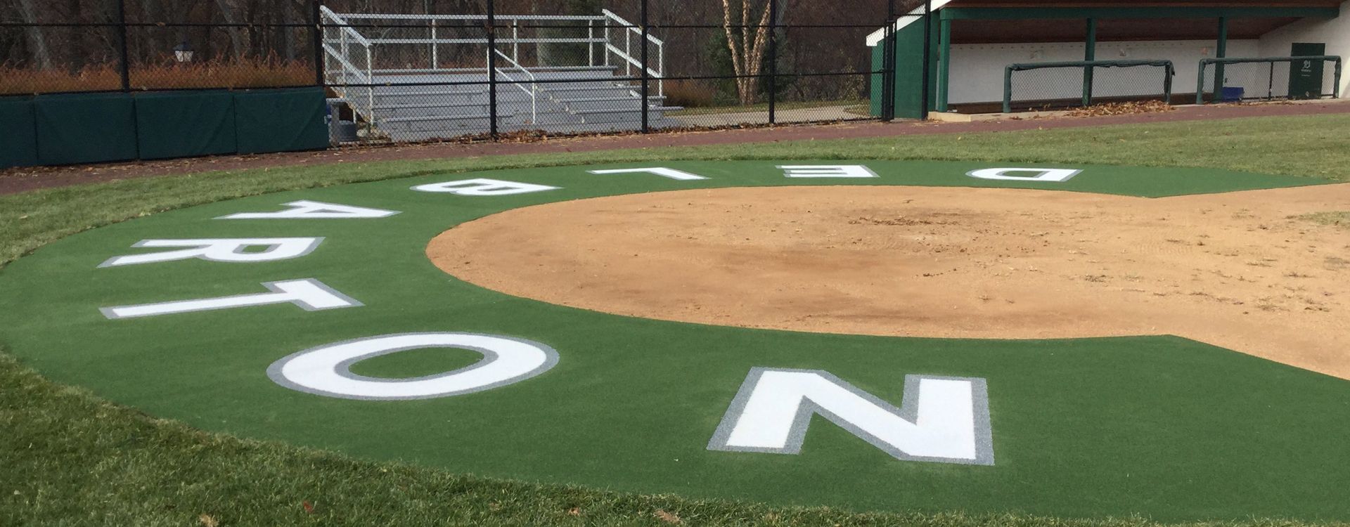 A soccer field with white lines and a goal in the background.