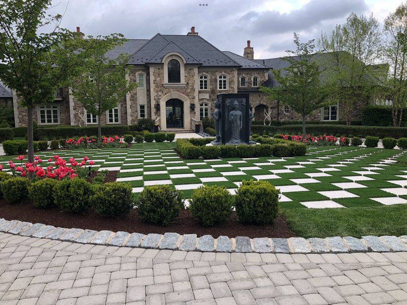 A large house with a checkered driveway in front of it.