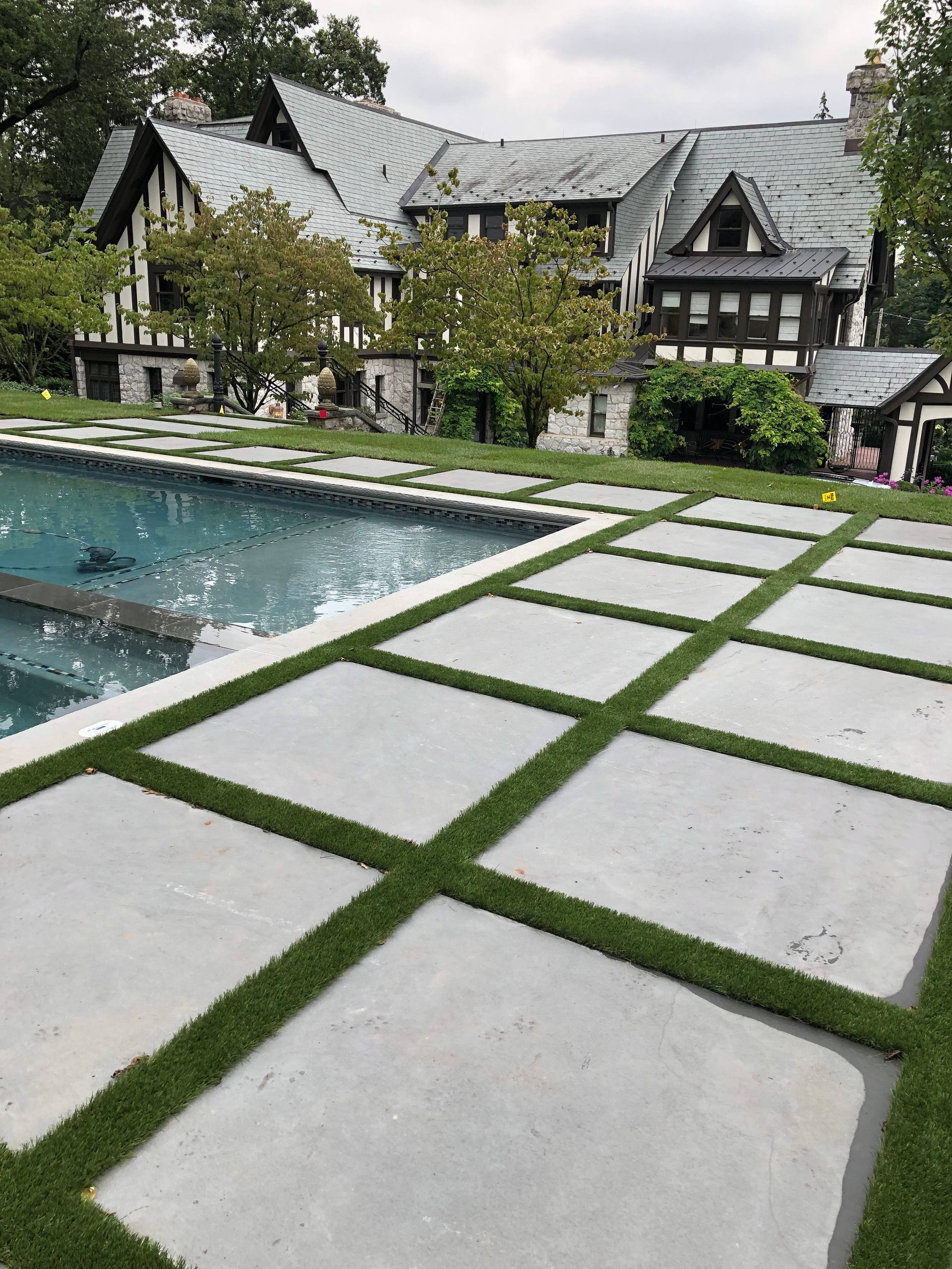 A large house with a swimming pool in front of it.
