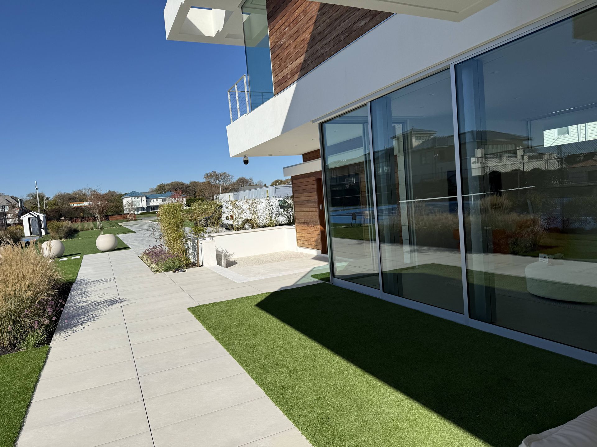 A modern house with a lot of windows and a walkway.