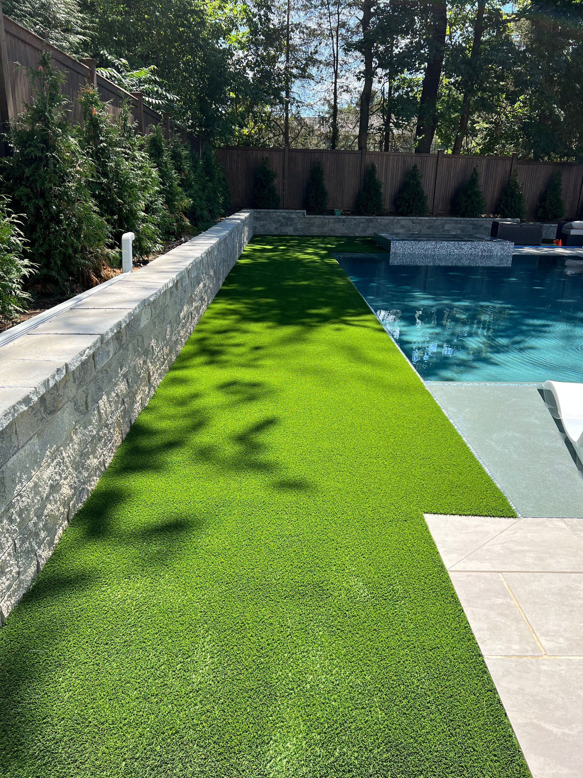 A swimming pool surrounded by a lush green lawn.