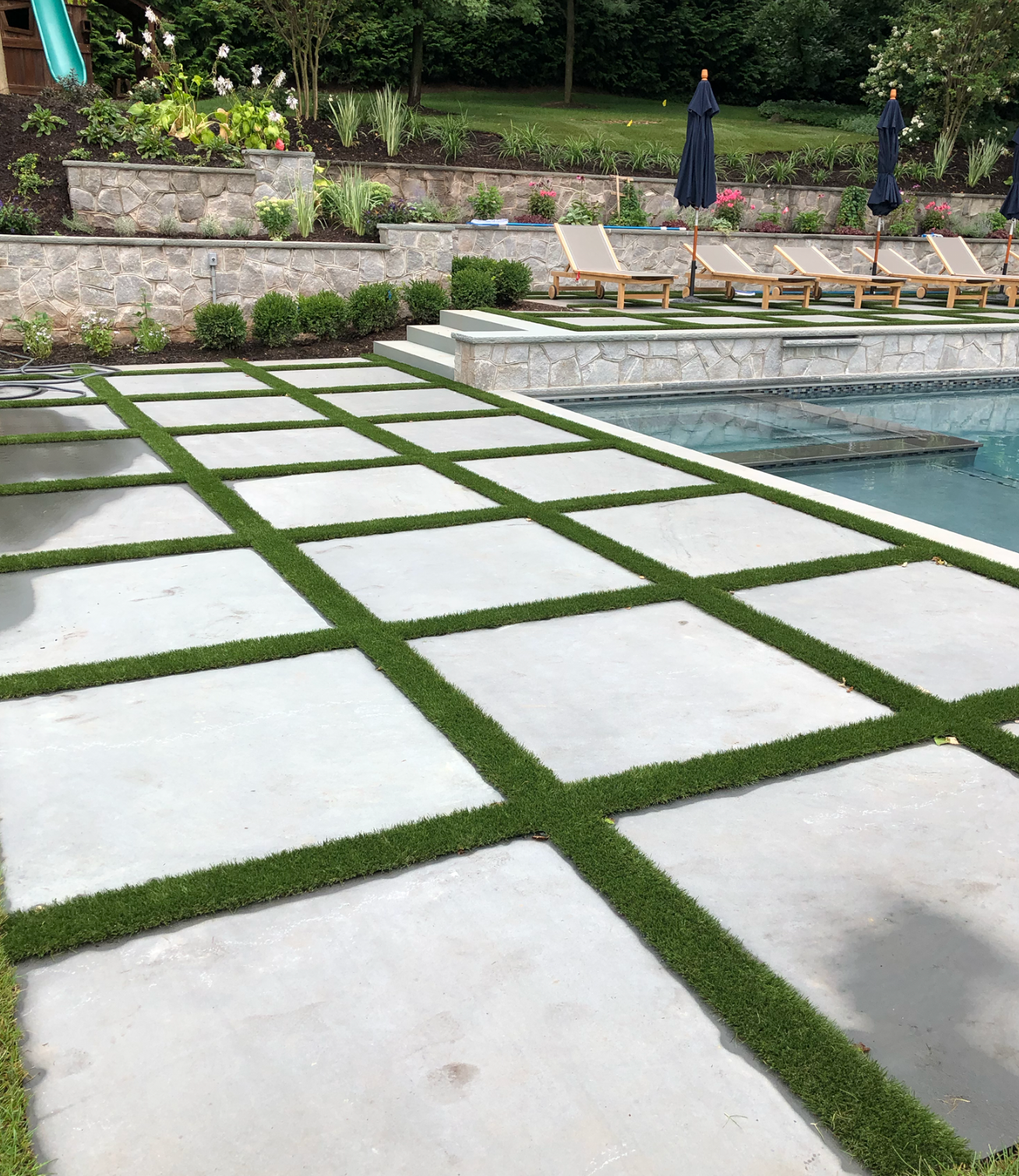 A patio with a swimming pool in the background.