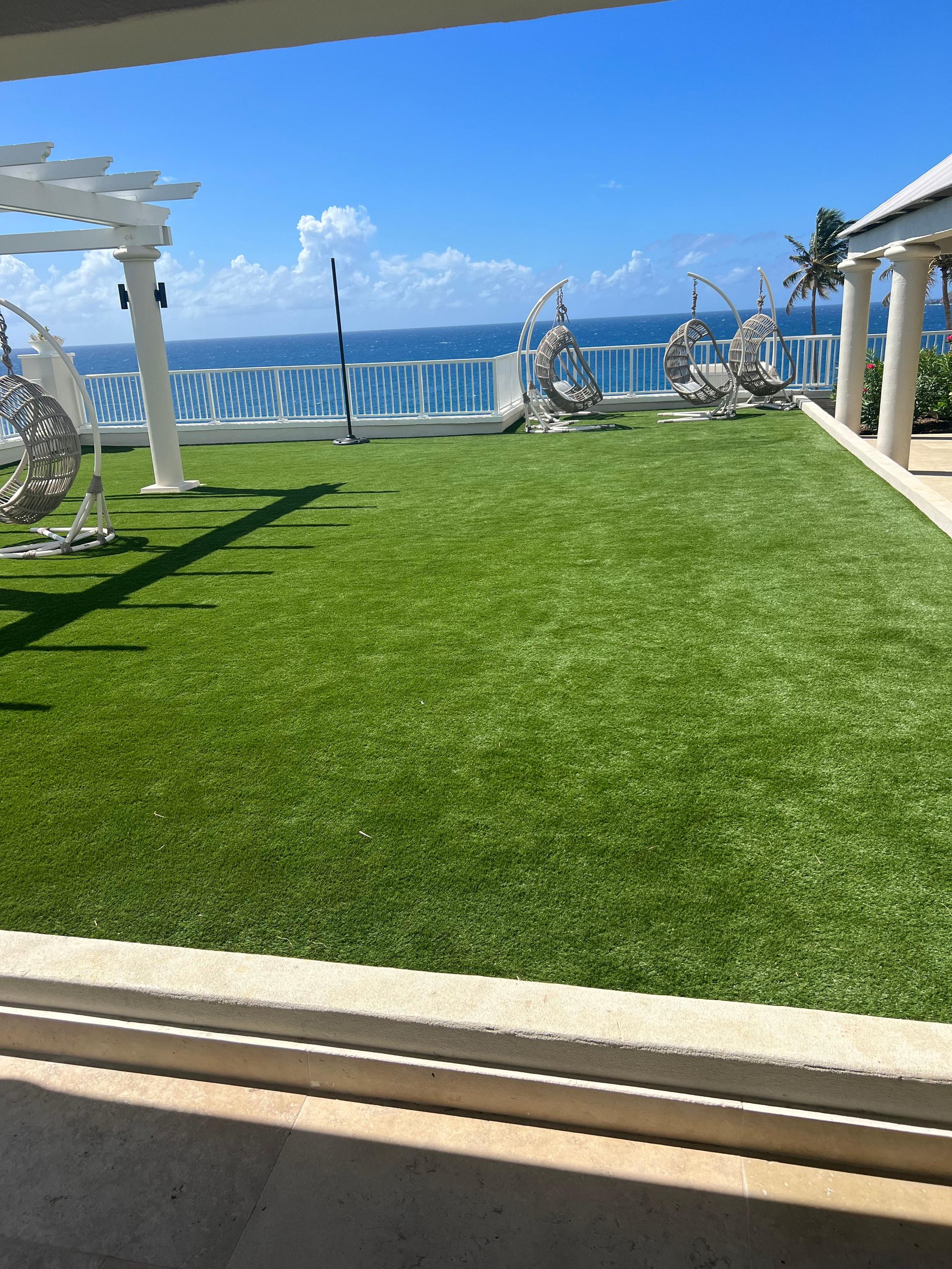 A lush green lawn with a view of the ocean.