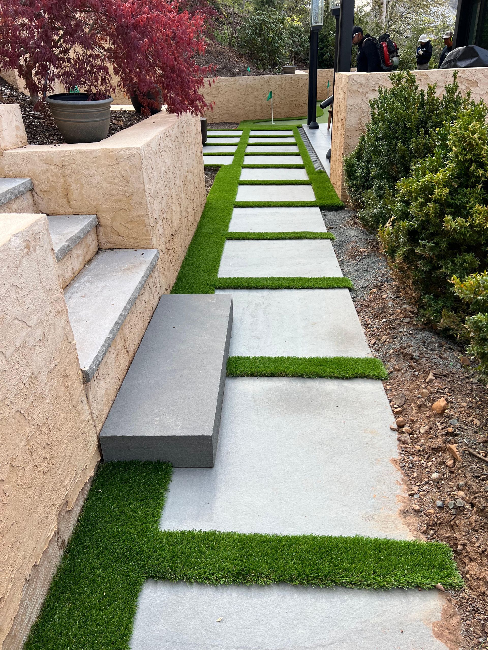 A concrete walkway with grass on the side of it.