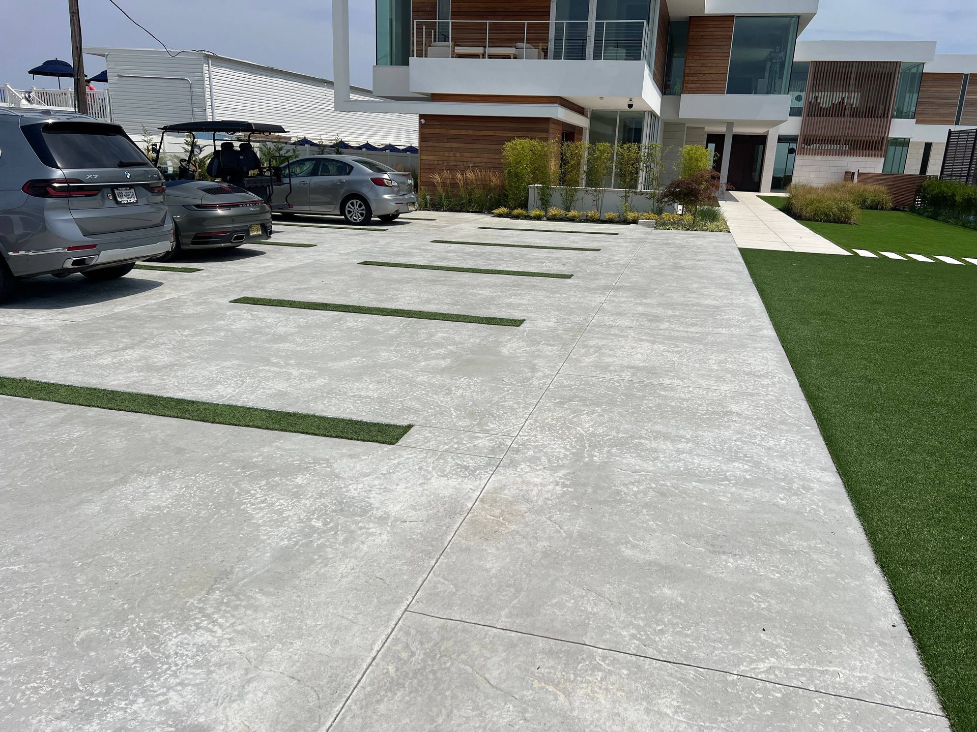 Cars are parked in a driveway in front of a house.