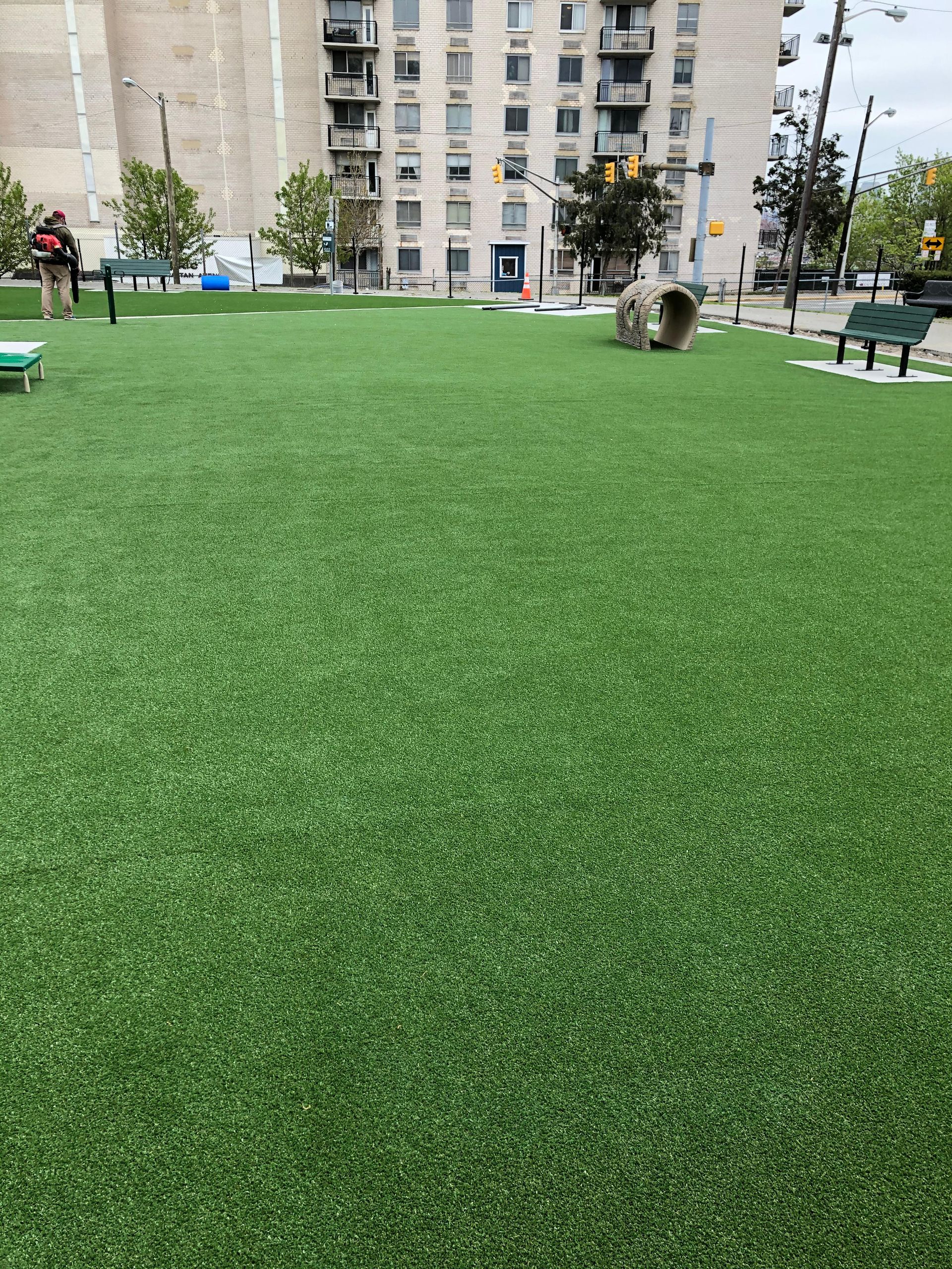 A large field of green grass with a building in the background.