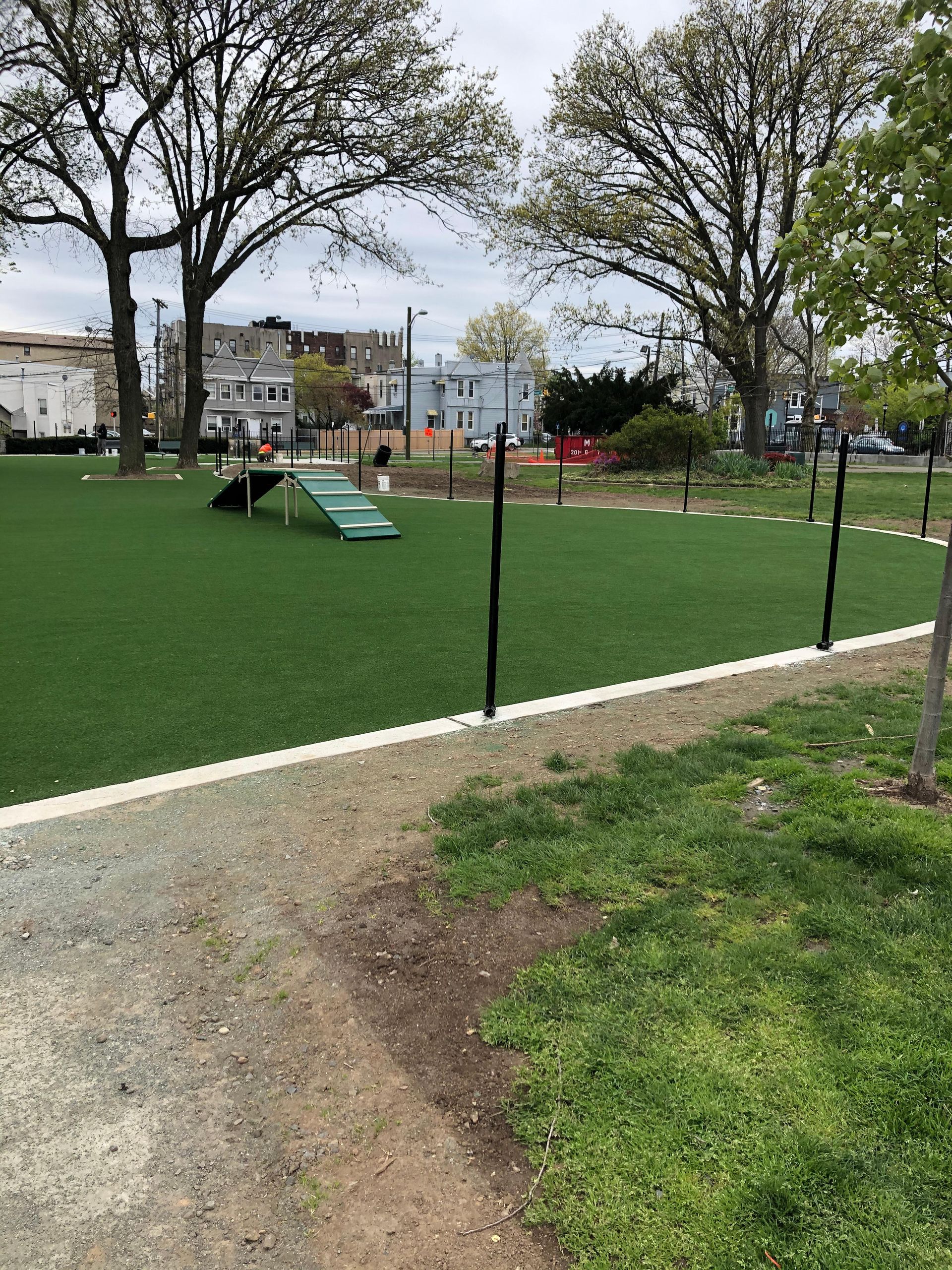 A park with a grassy field and trees in the background.