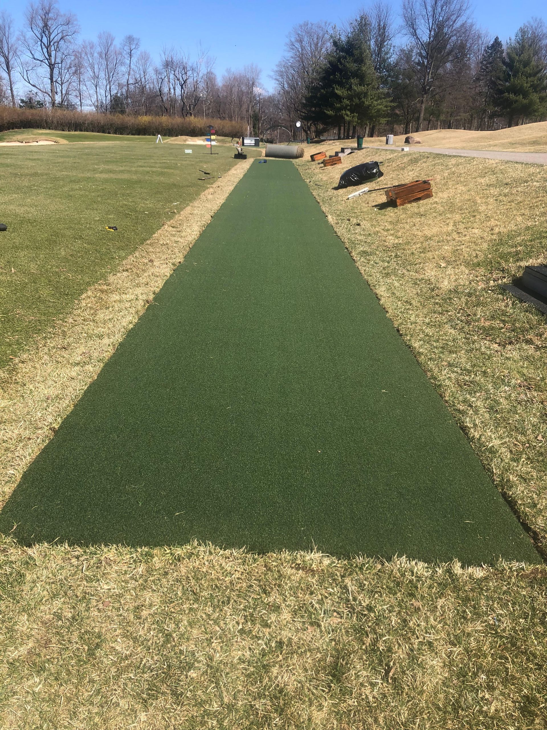 A grassy field with a green path going through it.