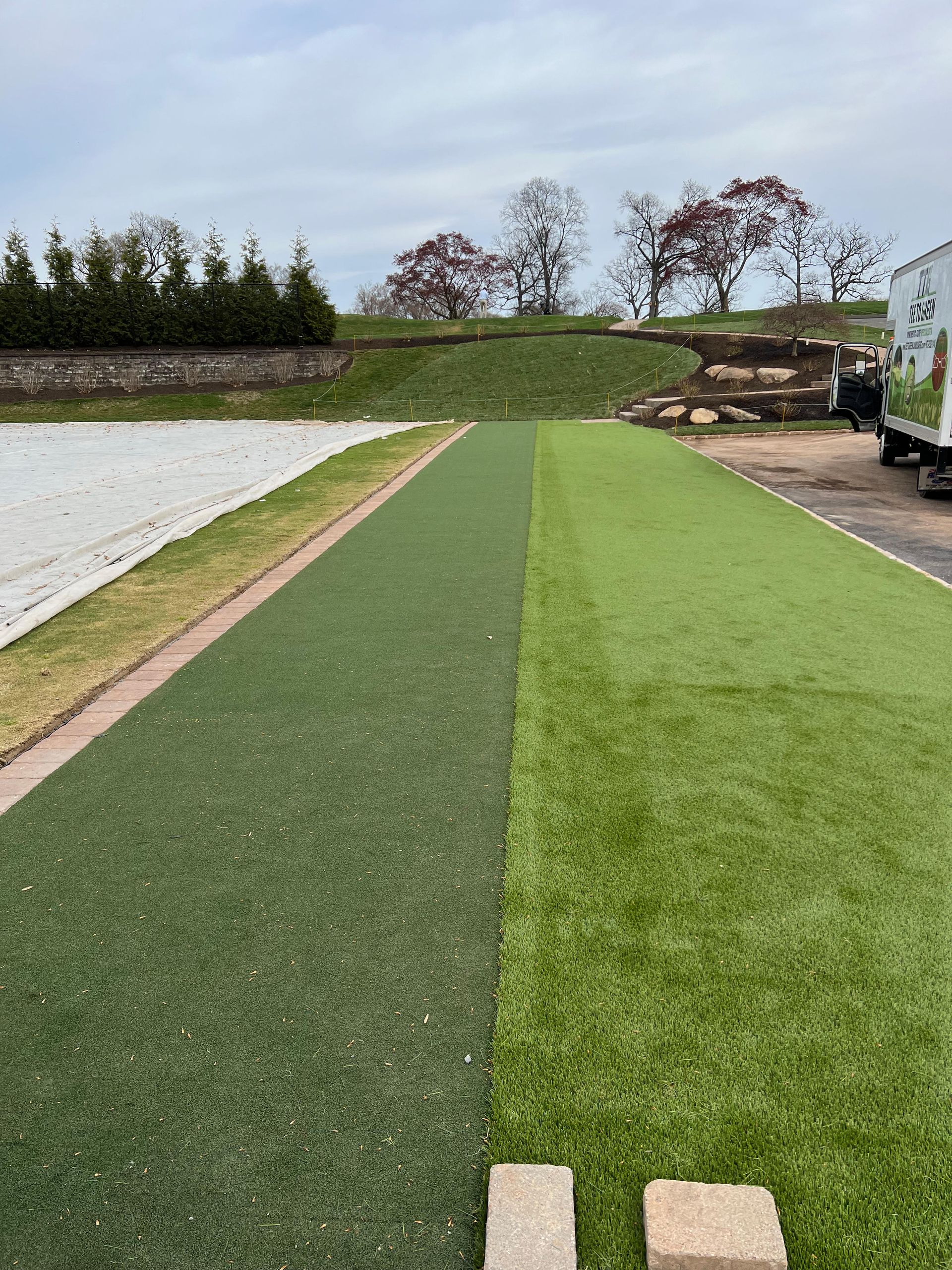 A grassy field with a truck parked in the background.