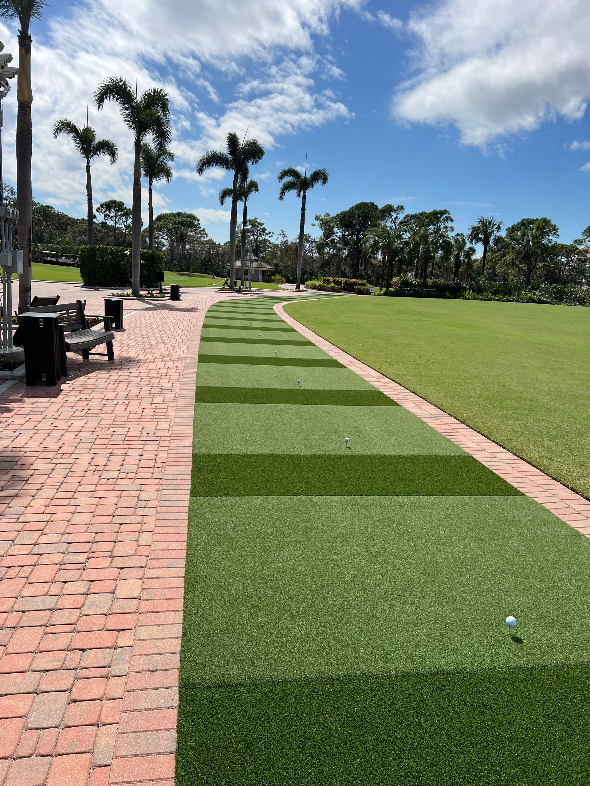 A brick walkway leading to a golf course.
