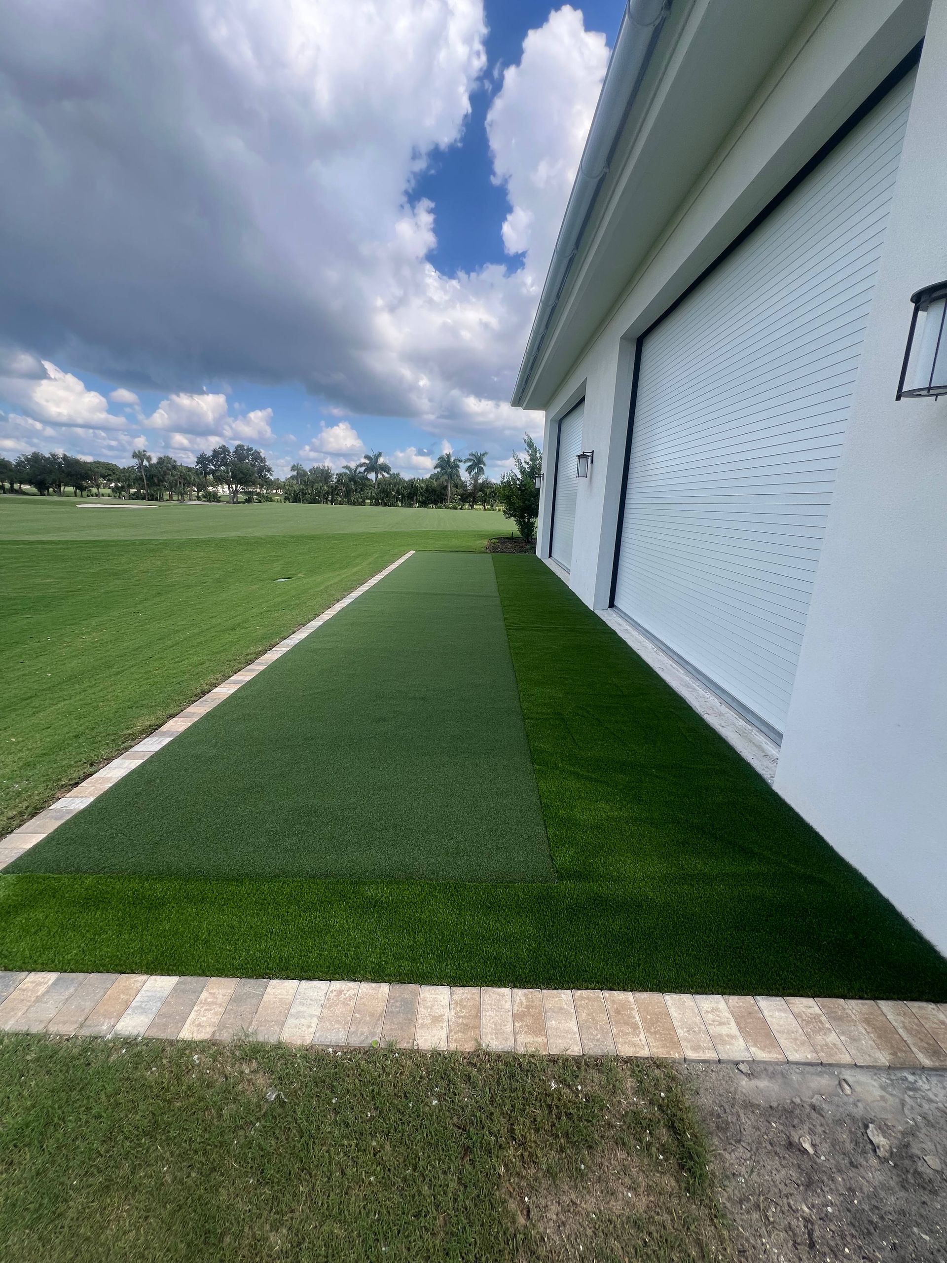 A white house with a lush green lawn in front of it.
