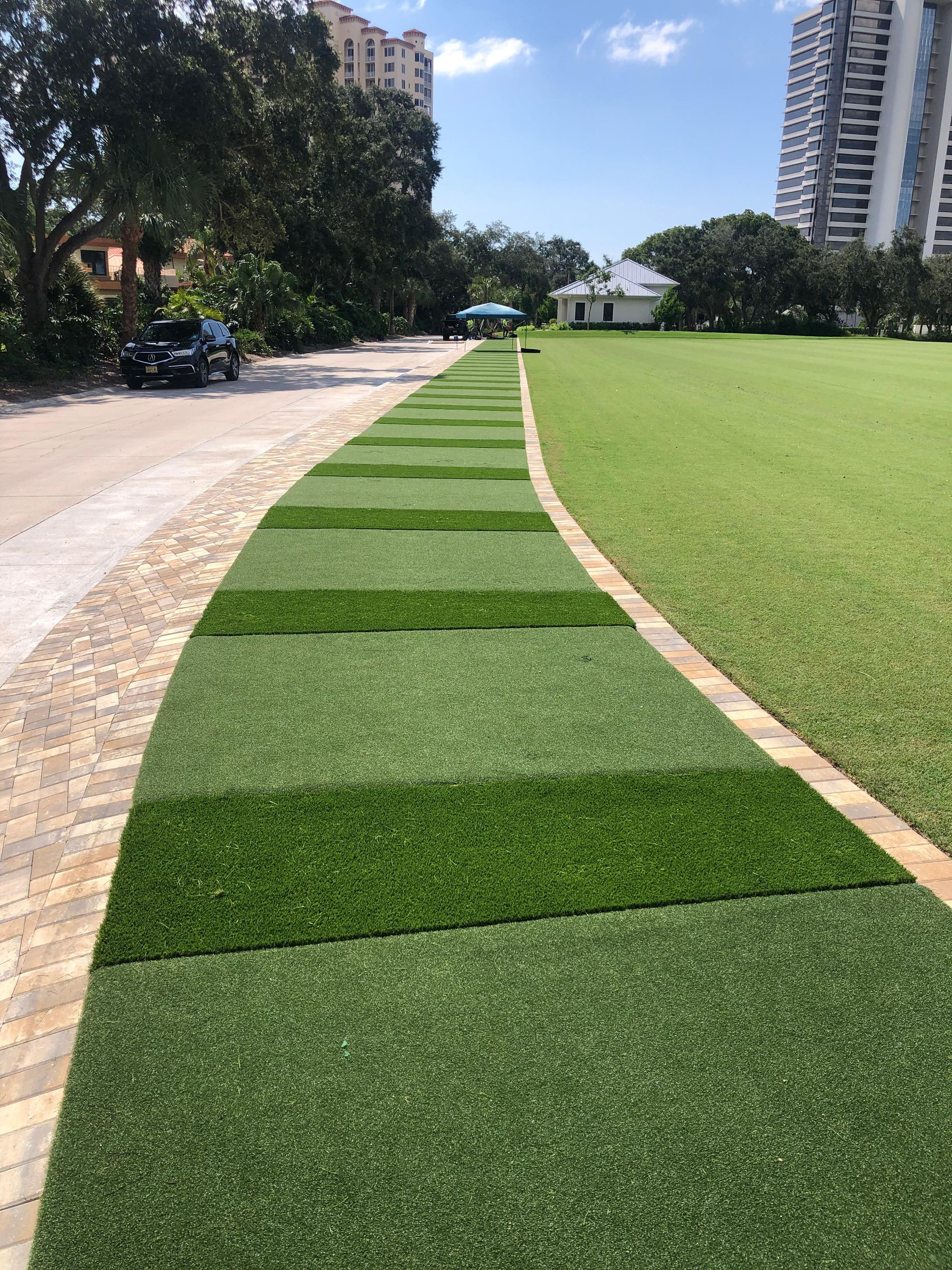 A row of grass lined walkways leading to a grassy field.