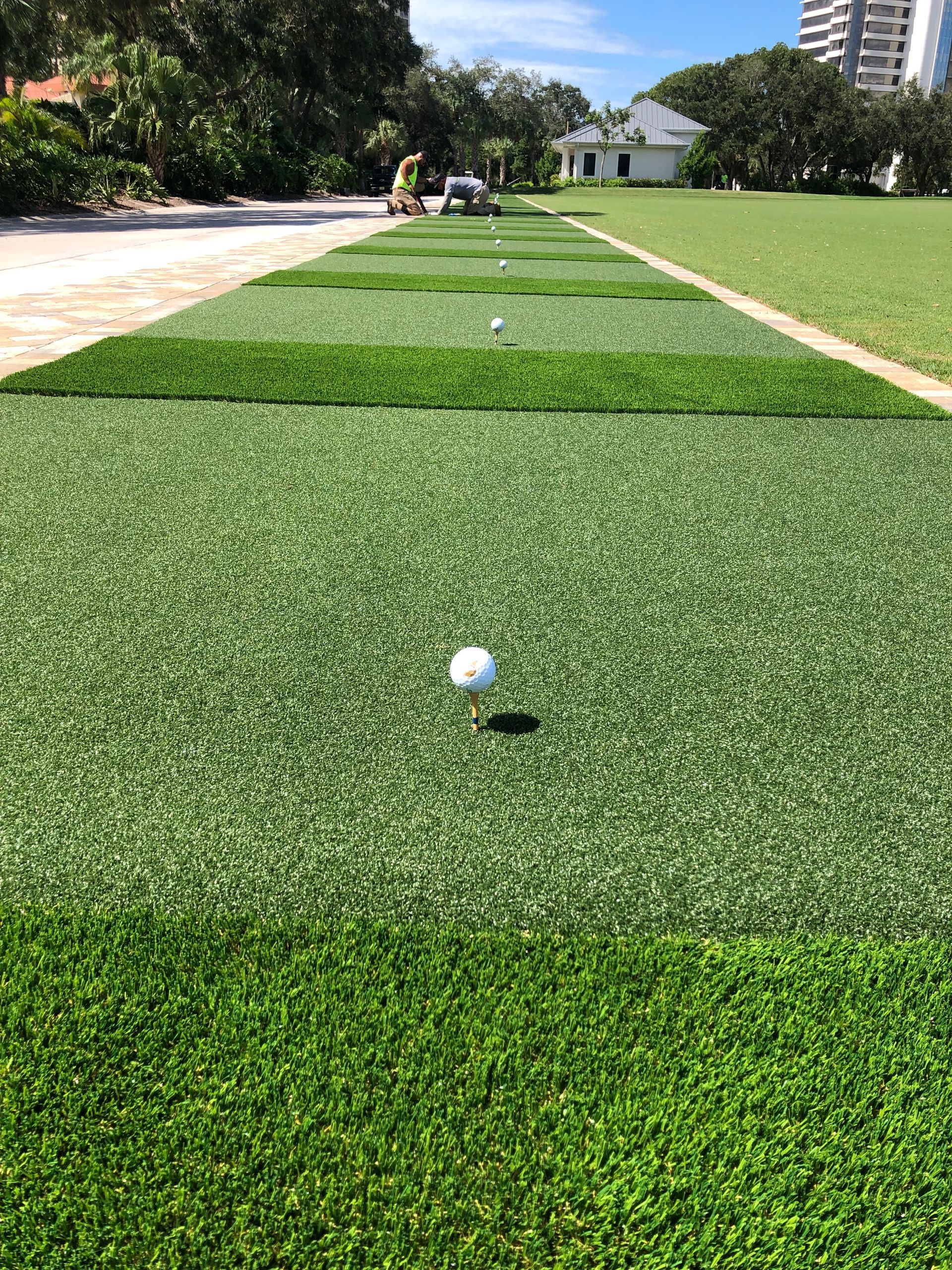 A golf ball is sitting on top of a green field.