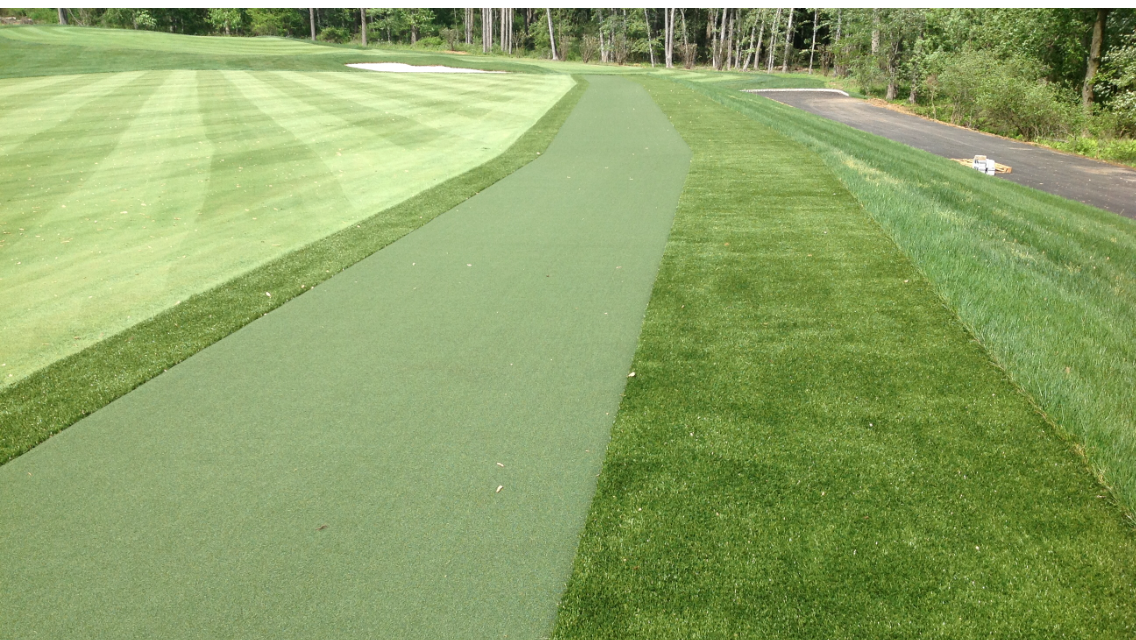 A golf course with a green path going through it.
