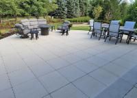 Outdoor patio with gray pavers, seating area, fire pit, and dining table.