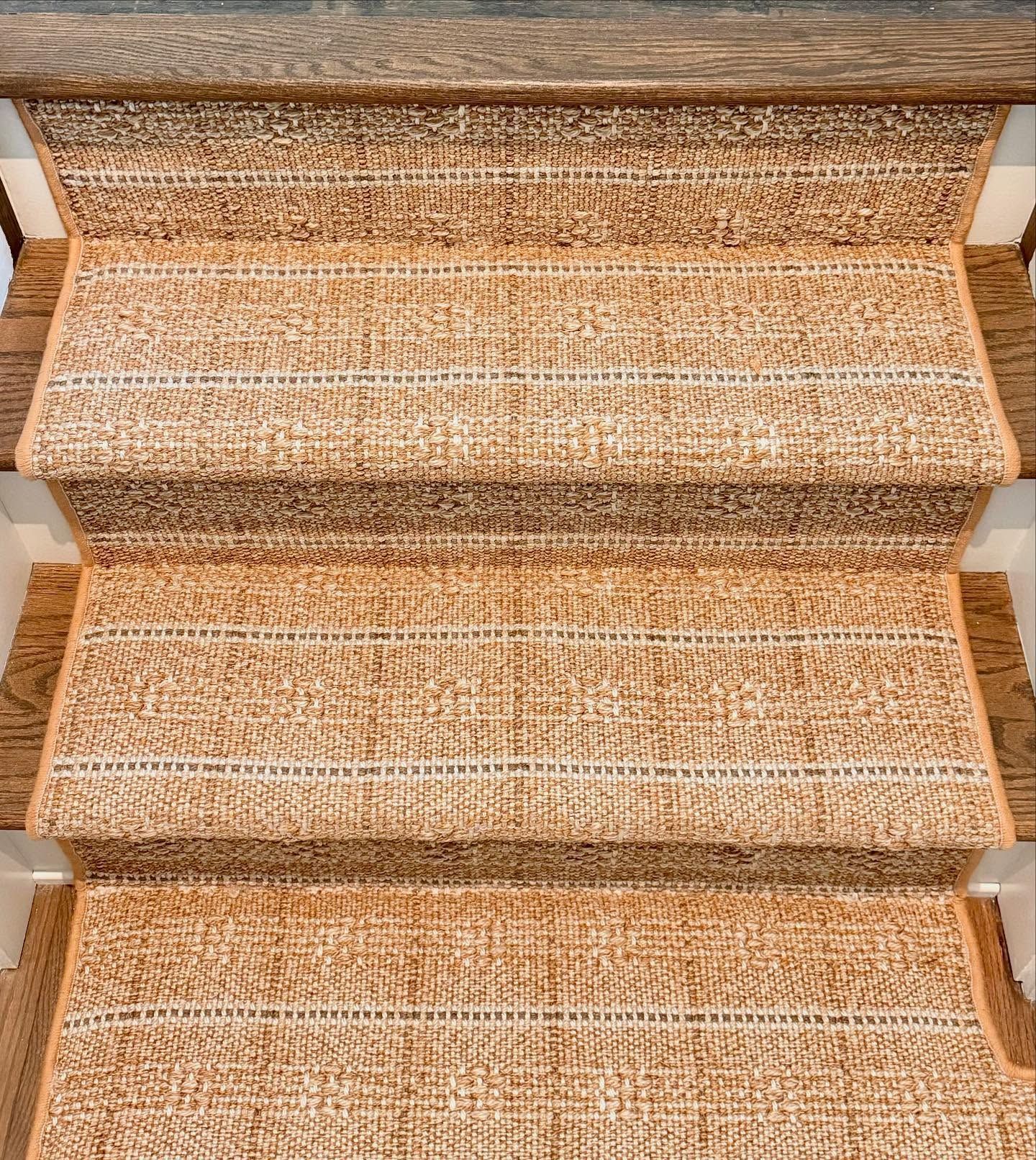 Staircase with brown carpet treads and wooden risers. Beige and white striped texture.