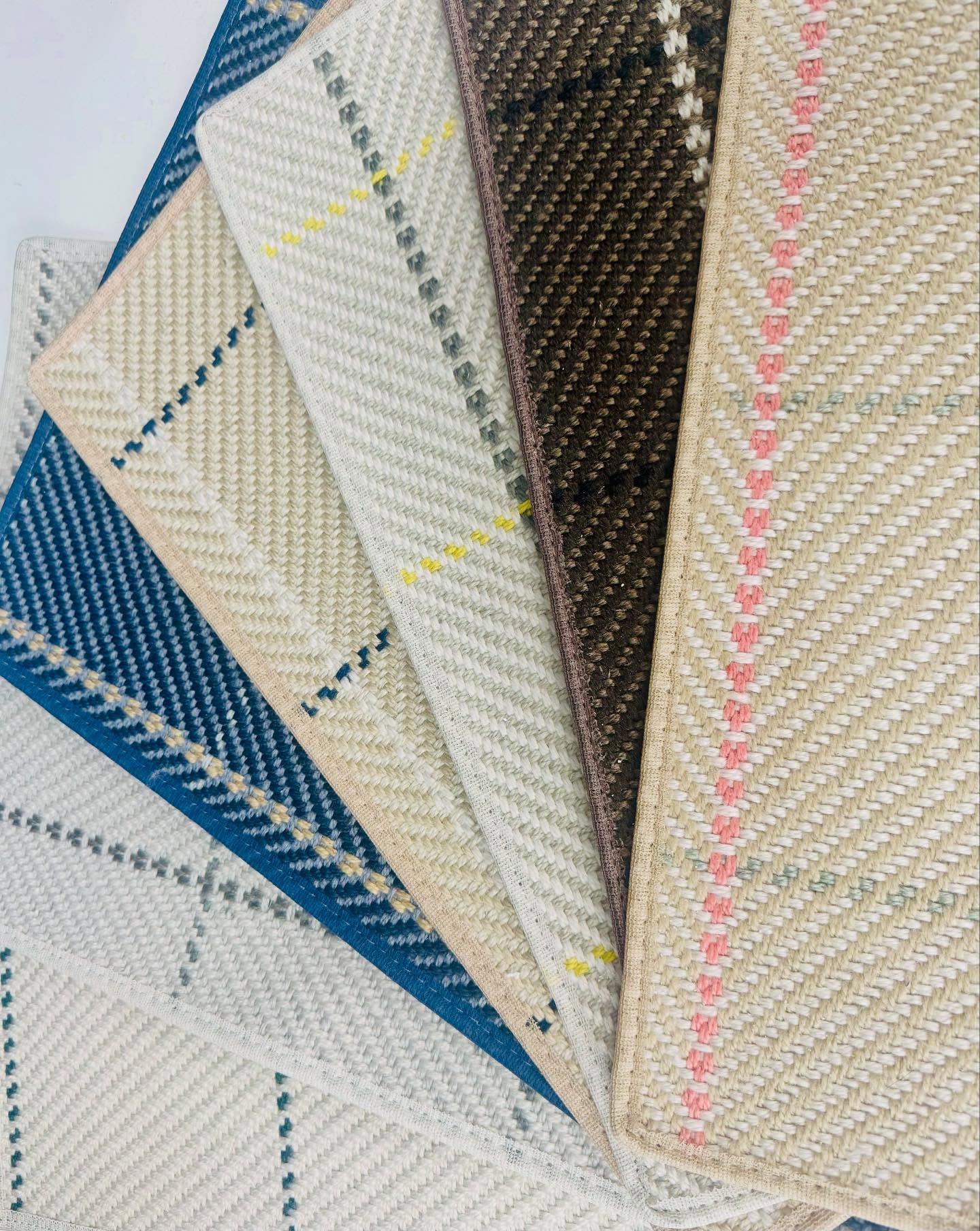 Assorted fabric swatches in various neutral colors with woven patterns, including plaids and herringbone.