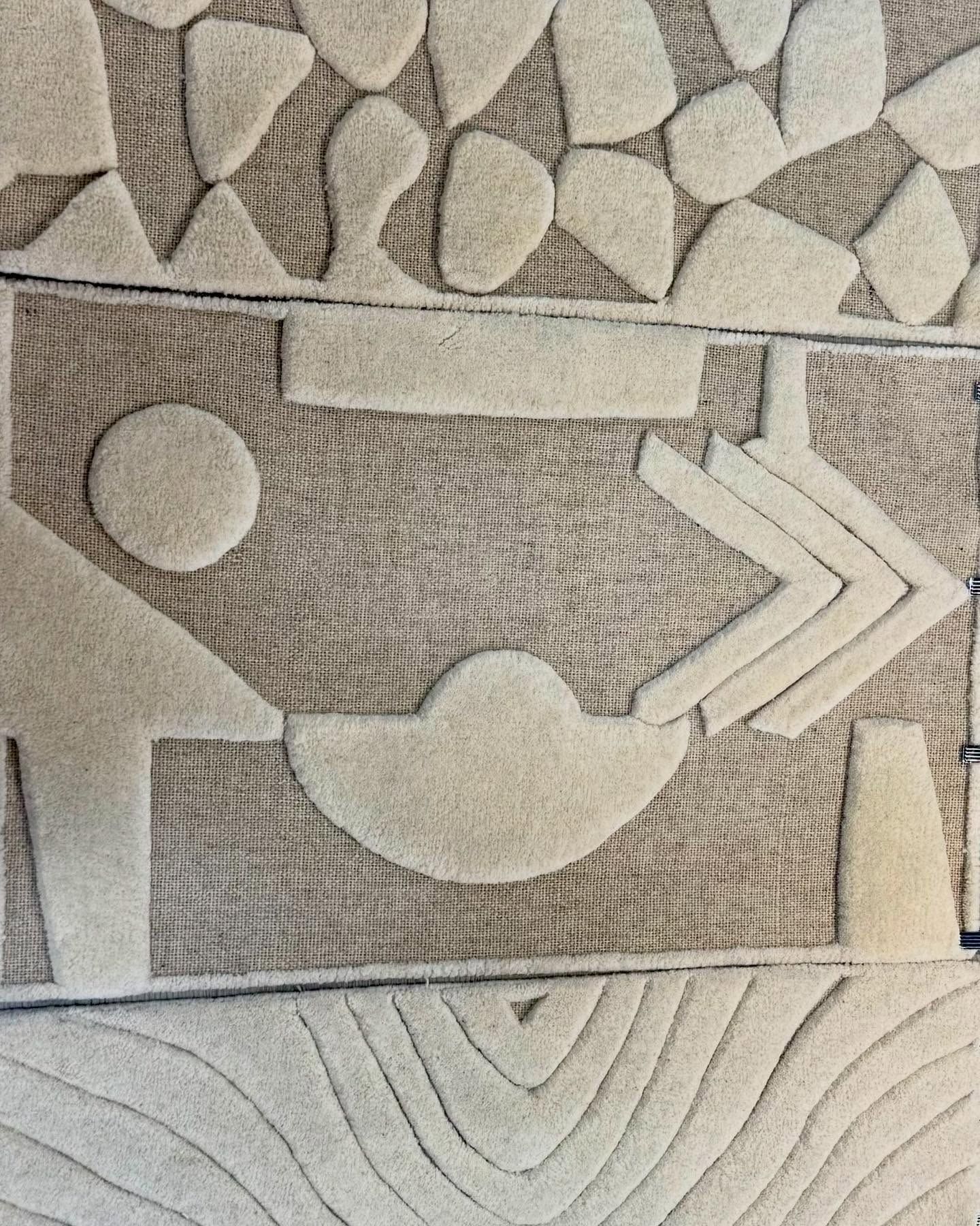 Abstract rug with geometric shapes in beige on a tan background.