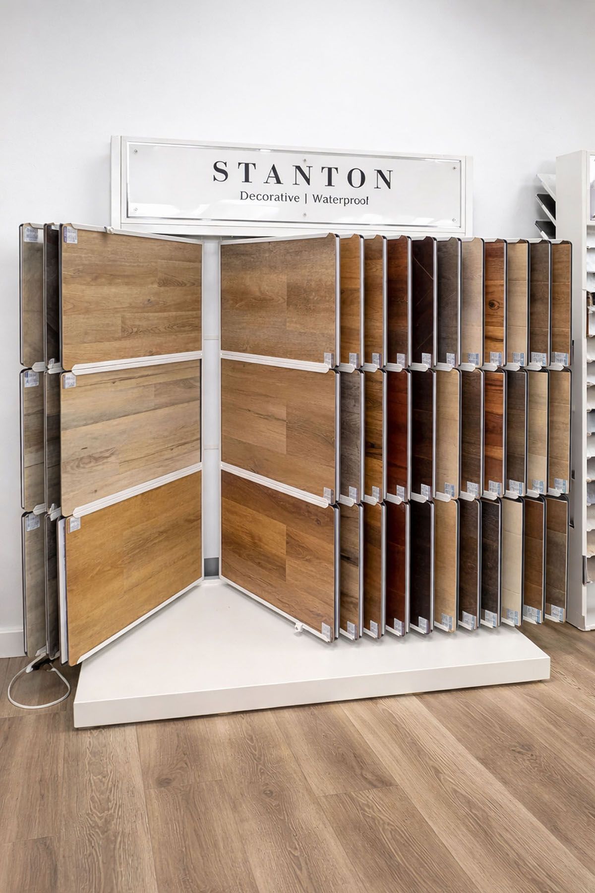 A retail display rack featuring a variety of wood-look flooring planks in a showroom