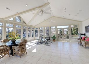 A large room with a lot of windows and a ceiling fan.
