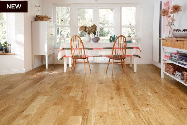 A dining room with a table and chairs and a wooden floor.