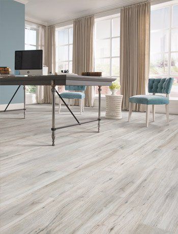 A room with a desk and chairs and a computer on it.