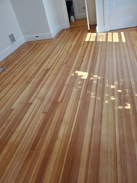 A room with a wooden floor and white walls.
