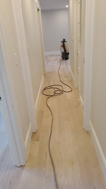 A long hallway with a vacuum cleaner on the floor.