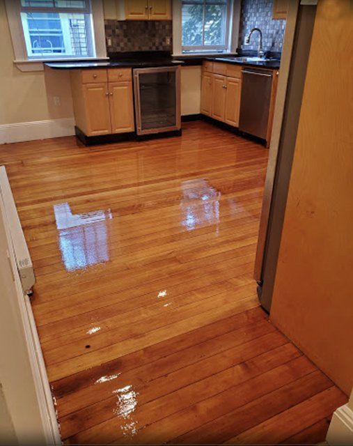 A kitchen with hardwood floors and stainless steel appliances