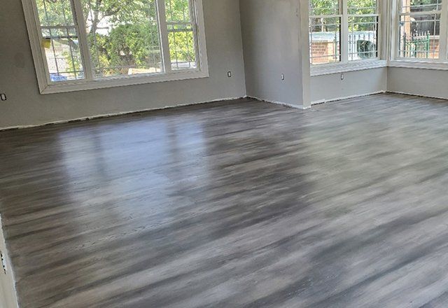 A living room with hardwood floors and lots of windows.