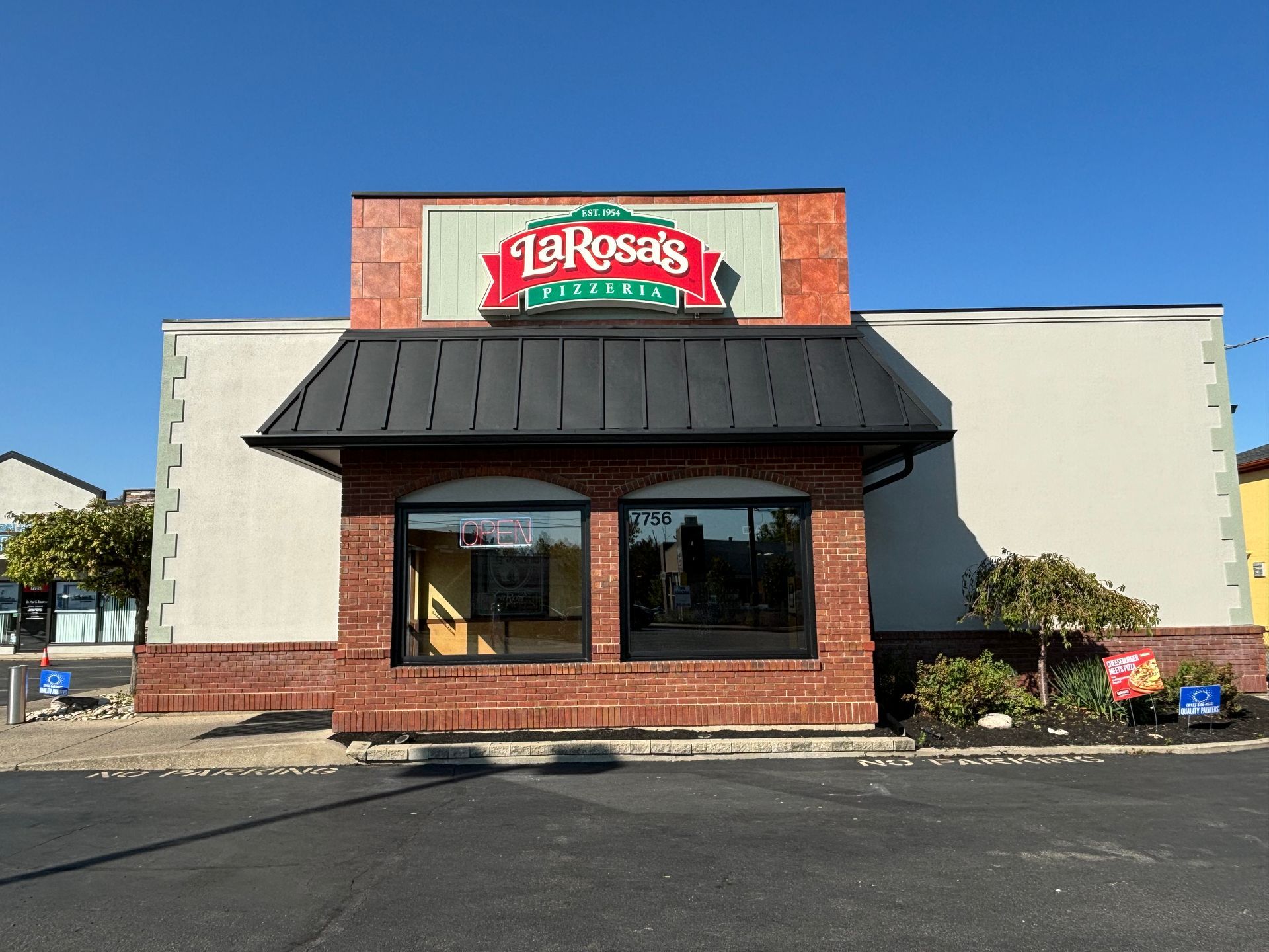 LaRosa's Pizzeria restaurant exterior with a black awning and sign under a clear, blue sky.