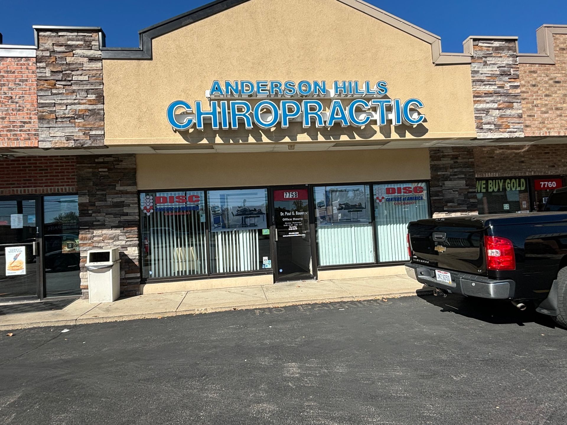 Anderson Hills Chiropractic storefront with blue signage, brick facade, and black pickup truck.