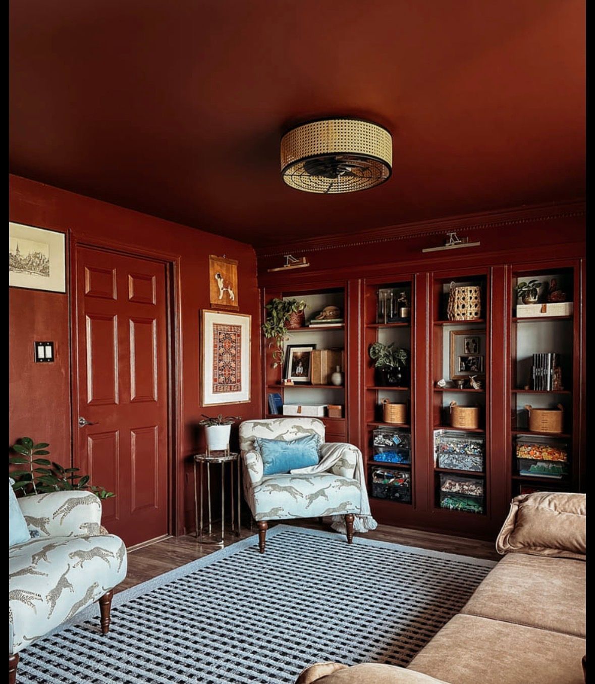 Living room with blue sofa, fireplace, chandelier, and a wooden door with a view of outside.