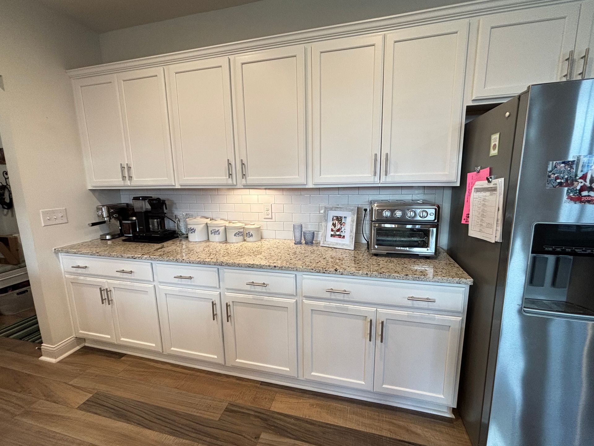 Formal dining room with blue walls, white trim, wood floor, and chandelier.