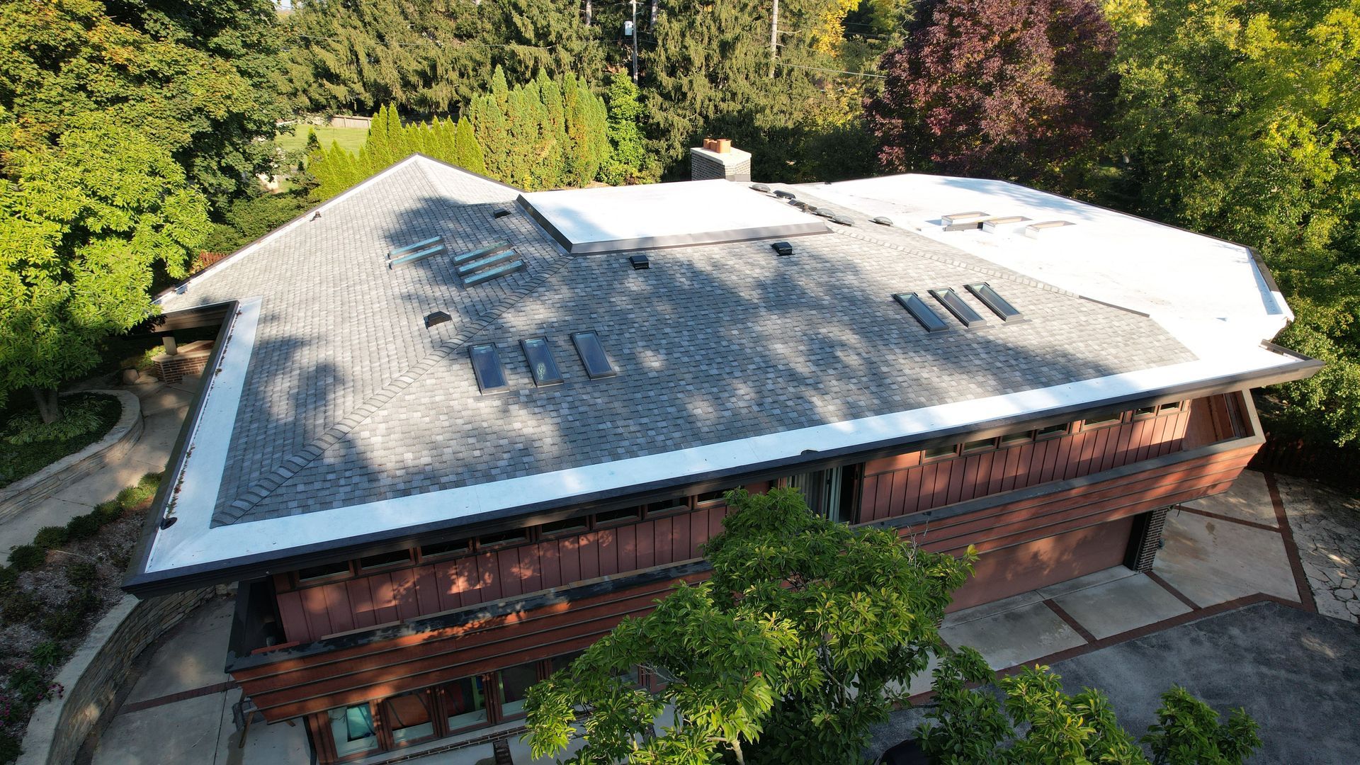 An aerial view of a house with a roof that is covered in shingles.
