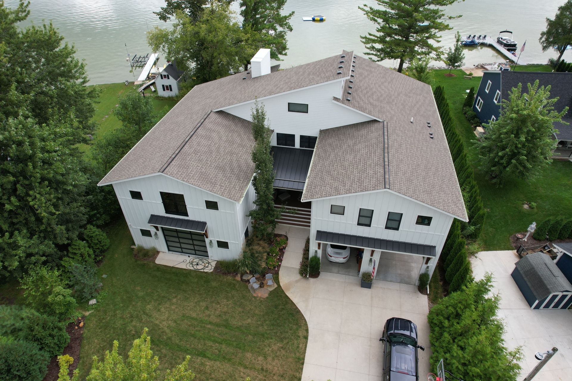 An aerial view of a large white house with a car parked in front of it.