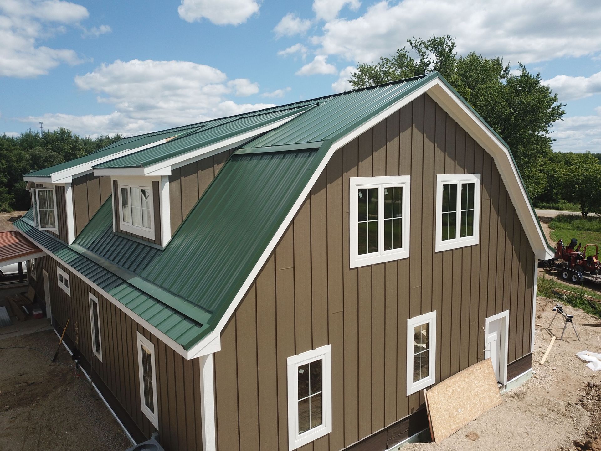An aerial view of a barn with a green roof and white trim.