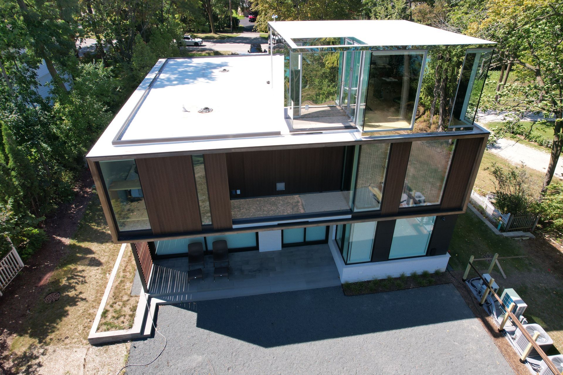 An aerial view of a modern house with a lot of windows.