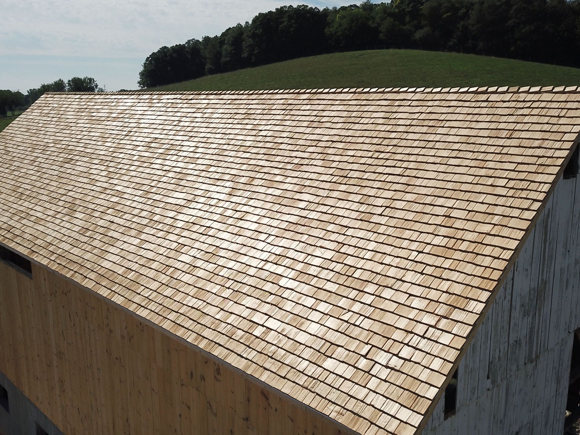 A large wooden roof with a field in the background.
